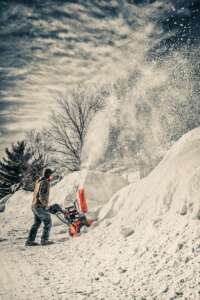 man using snow blower